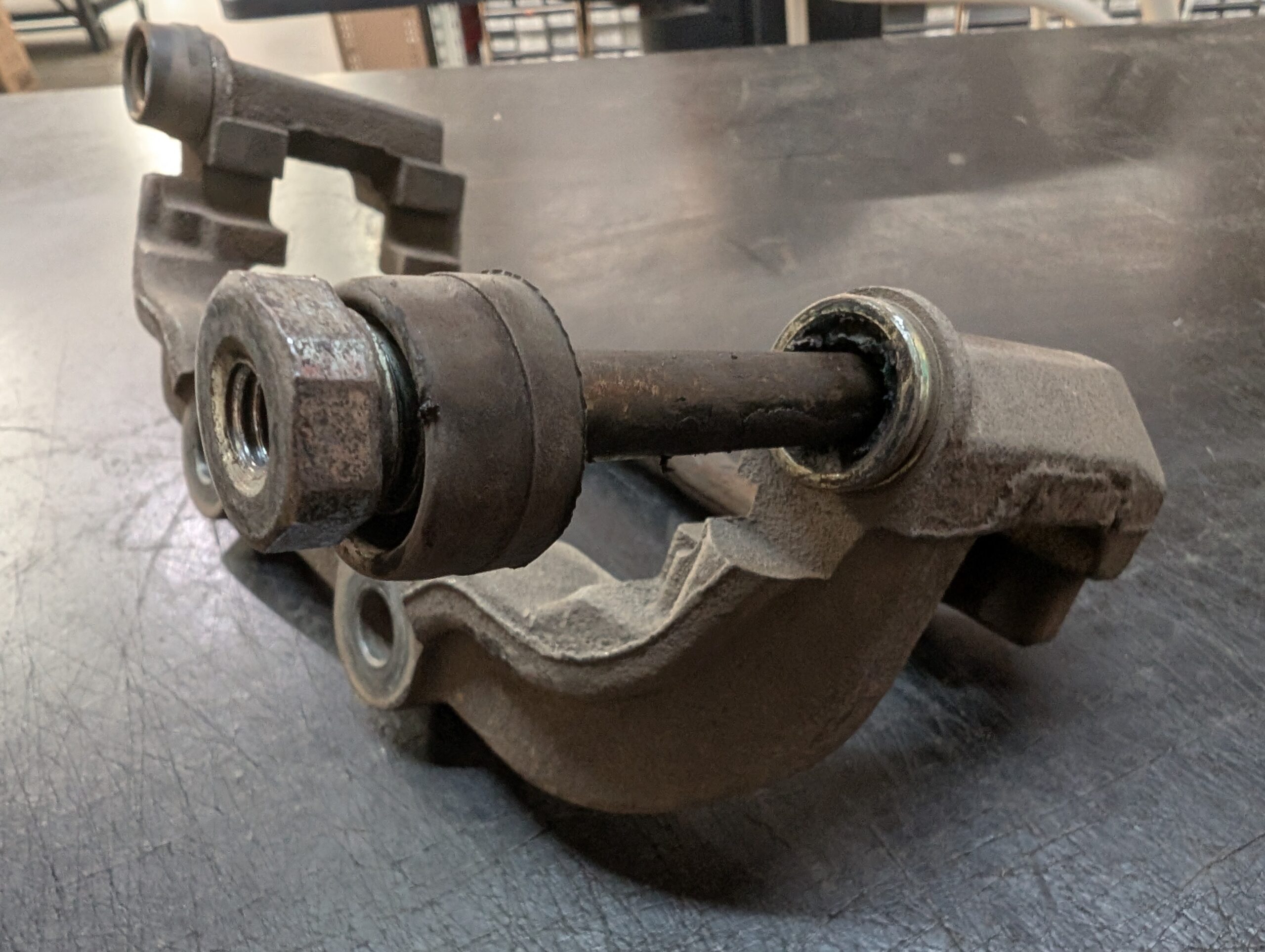 Photo of a floating caliper bracket with worn caliper guide pins.